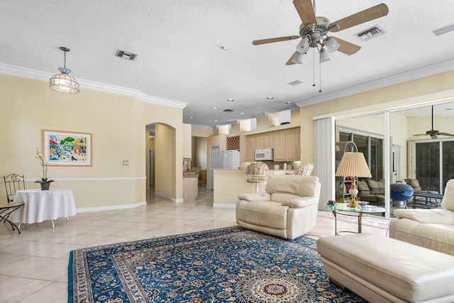 living room featuring a textured ceiling, crown molding, light tile patterned flooring, and ceiling fan