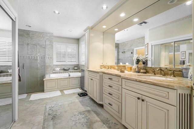 bathroom featuring a textured ceiling, vanity, and separate shower and tub