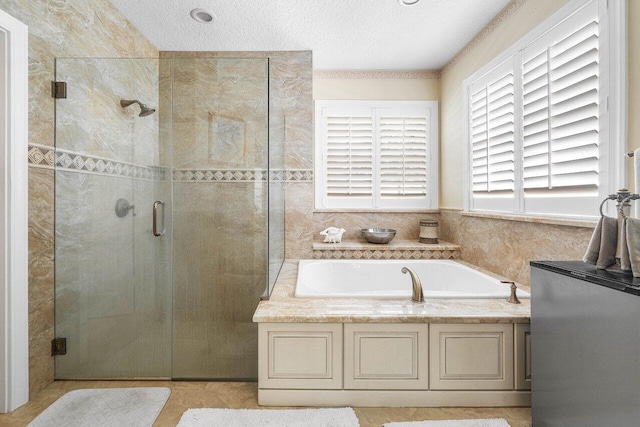 bathroom featuring separate shower and tub and a textured ceiling