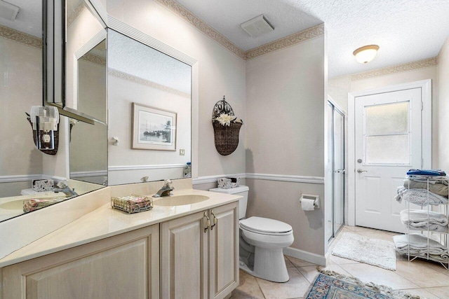 bathroom featuring vanity, tile patterned floors, an enclosed shower, and toilet