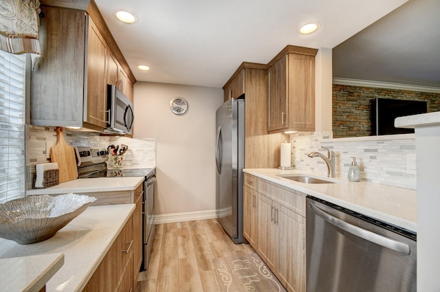 kitchen featuring appliances with stainless steel finishes, backsplash, crown molding, light hardwood / wood-style flooring, and sink