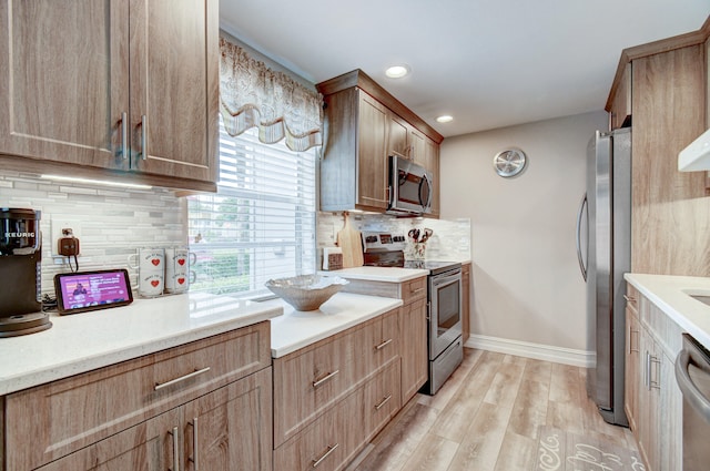 kitchen with backsplash, light hardwood / wood-style floors, and stainless steel appliances