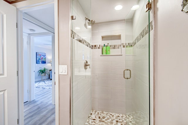 bathroom with a shower with door and hardwood / wood-style flooring