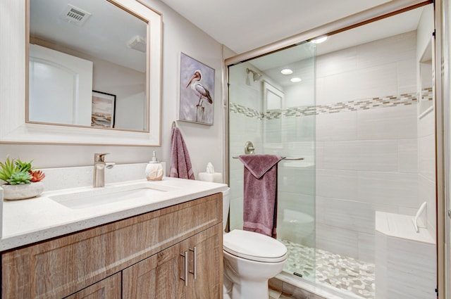 bathroom featuring vanity, toilet, and a shower with door