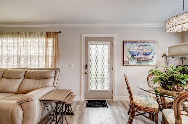 foyer entrance with light hardwood / wood-style flooring and crown molding