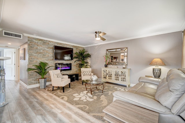 living room with ceiling fan, a stone fireplace, crown molding, and wood-type flooring