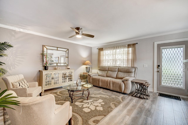 living room with light hardwood / wood-style flooring, ceiling fan, and ornamental molding