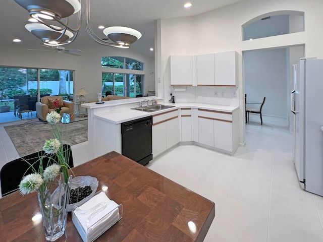 kitchen with kitchen peninsula, white cabinets, white fridge with ice dispenser, dishwasher, and sink