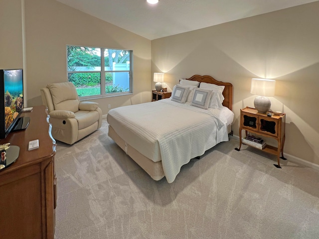 bedroom with vaulted ceiling and light carpet