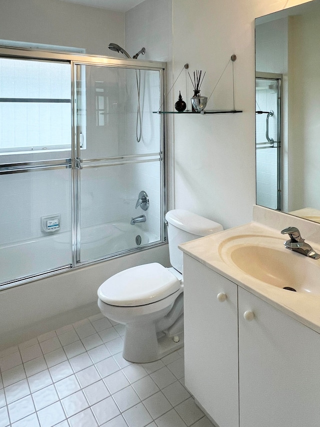 full bathroom with vanity, combined bath / shower with glass door, toilet, and tile patterned flooring