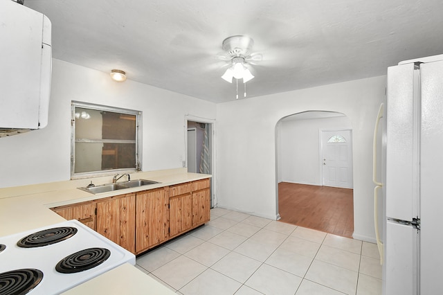 kitchen with ceiling fan, sink, white refrigerator, stove, and light tile patterned flooring