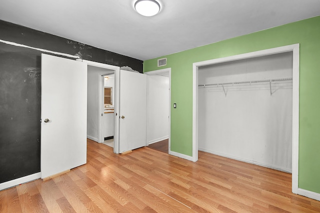 unfurnished bedroom with light hardwood / wood-style floors and a closet