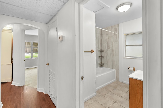 bathroom with vanity, wood-type flooring, and tiled shower / bath combo