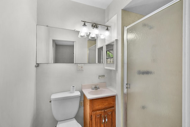 bathroom featuring toilet, vanity, and walk in shower