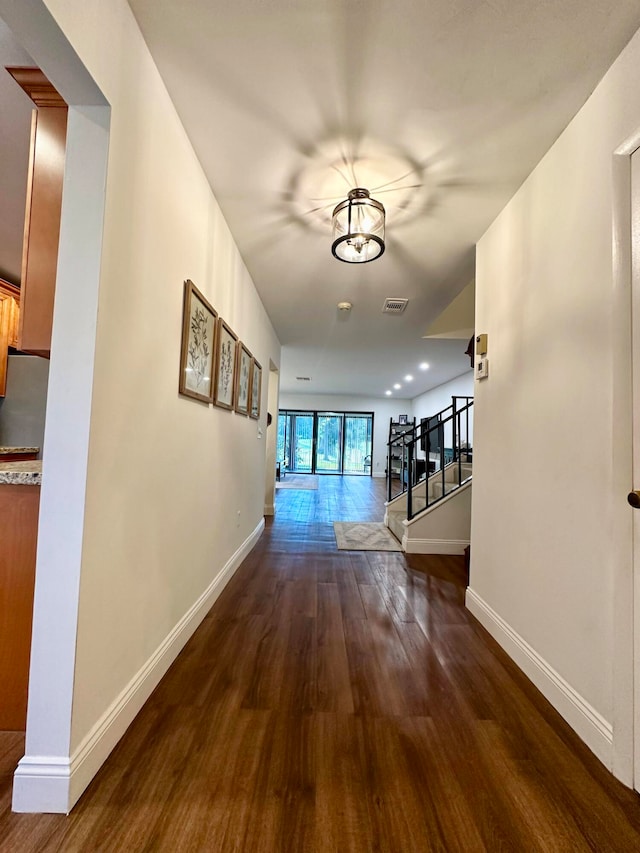 hall featuring a notable chandelier and dark hardwood / wood-style floors