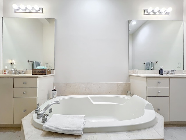 bathroom featuring vanity and tiled tub