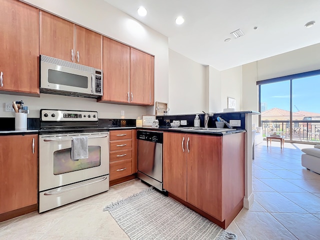 kitchen with light tile patterned flooring, kitchen peninsula, stainless steel appliances, and sink