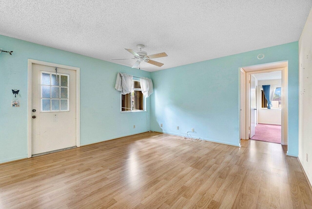 unfurnished room with light wood-type flooring, ceiling fan, and a textured ceiling