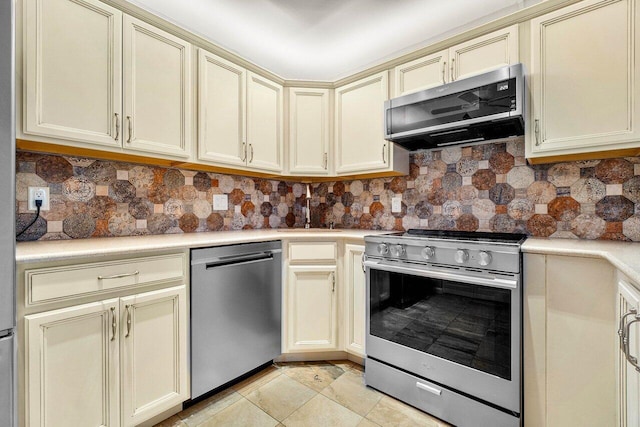 kitchen with backsplash, cream cabinets, appliances with stainless steel finishes, and sink