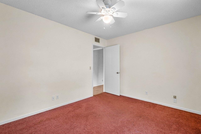 carpeted spare room with ceiling fan and a textured ceiling