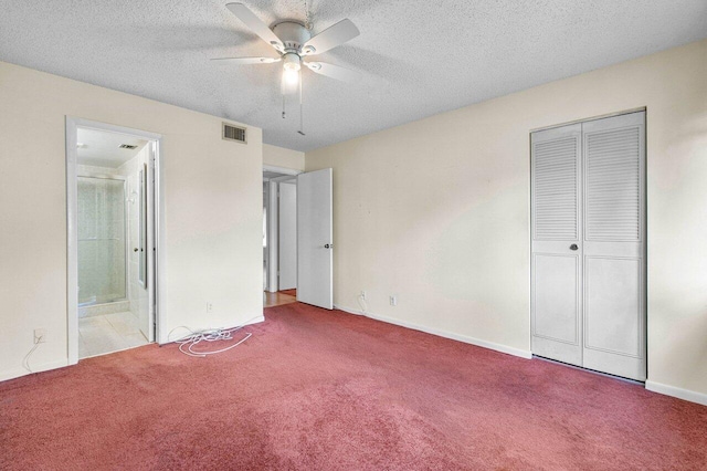 unfurnished bedroom with ceiling fan, a textured ceiling, connected bathroom, and light carpet