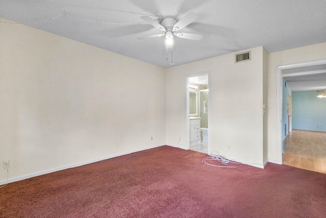 carpeted empty room with ceiling fan and a textured ceiling