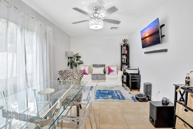 tiled living room with ceiling fan with notable chandelier