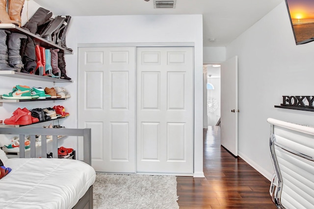 bedroom featuring dark wood-type flooring and a closet