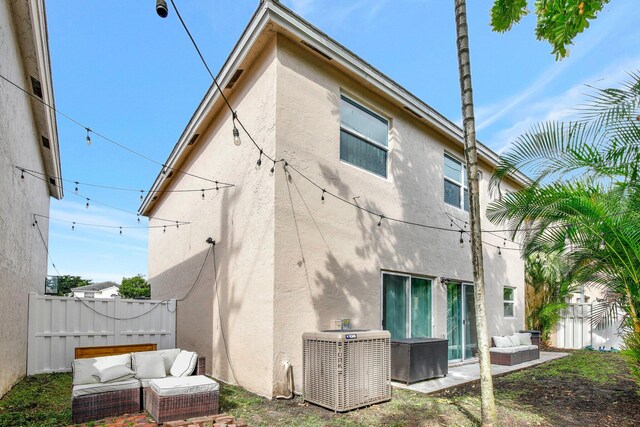 rear view of property featuring a patio area, central AC unit, and outdoor lounge area