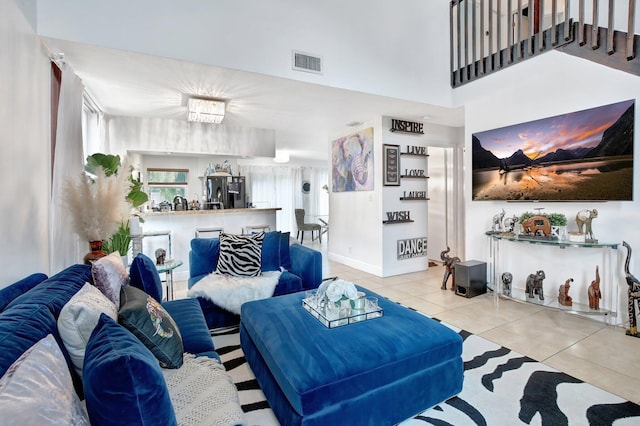 tiled living room with an inviting chandelier and a high ceiling