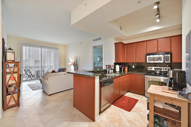 kitchen with light tile patterned flooring, sink, kitchen peninsula, stainless steel appliances, and backsplash