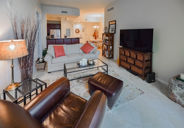 tiled living room with a notable chandelier