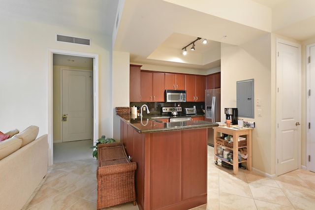 kitchen featuring electric panel, kitchen peninsula, decorative backsplash, appliances with stainless steel finishes, and light tile patterned floors