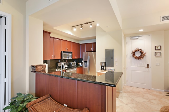 kitchen with electric panel, appliances with stainless steel finishes, kitchen peninsula, and decorative backsplash