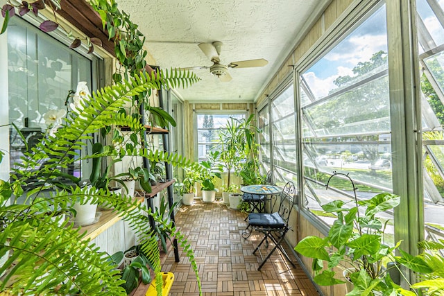 unfurnished sunroom with ceiling fan