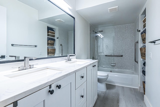 full bathroom with wood-type flooring, vanity, toilet, and tiled shower / bath