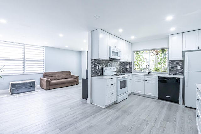 kitchen featuring light hardwood / wood-style floors, white appliances, and white cabinetry