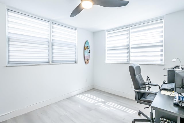 home office with light wood-type flooring and ceiling fan