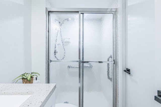 bathroom with vanity, toilet, and a shower with shower door