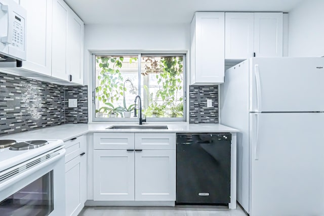 kitchen featuring white appliances, white cabinetry, sink, and tasteful backsplash