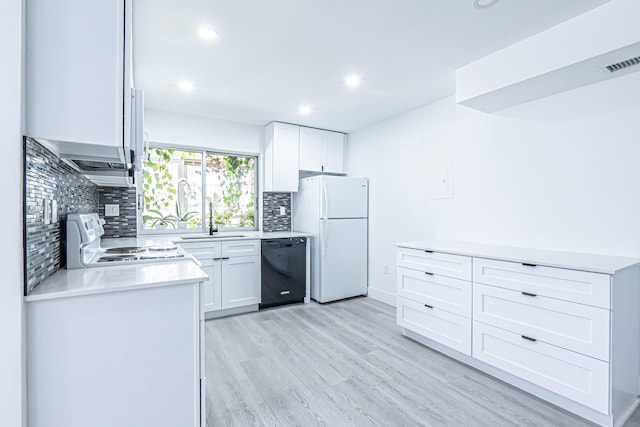 kitchen featuring black dishwasher, stove, white fridge, and white cabinetry