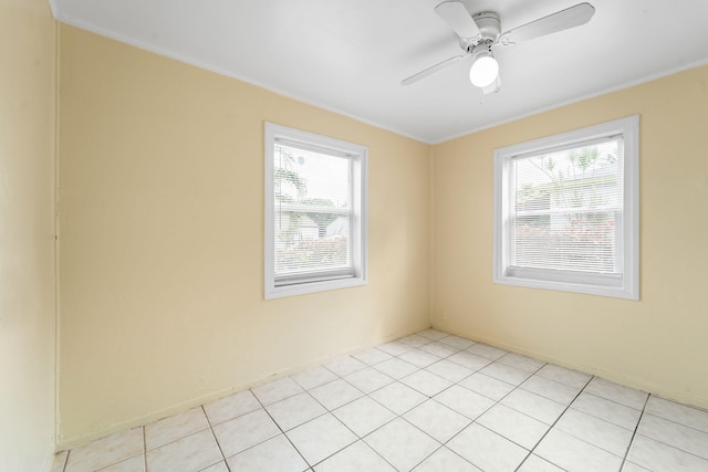 tiled spare room with ornamental molding and ceiling fan