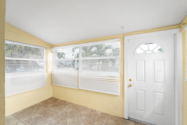 entrance foyer featuring vaulted ceiling and light tile patterned floors