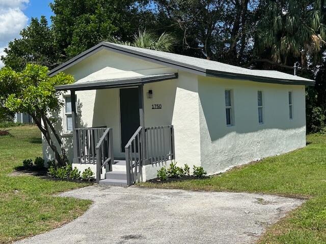 bungalow-style home with a front lawn