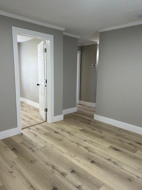 unfurnished room featuring crown molding and light wood-type flooring