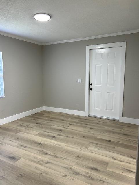 spare room featuring a textured ceiling and light wood-type flooring