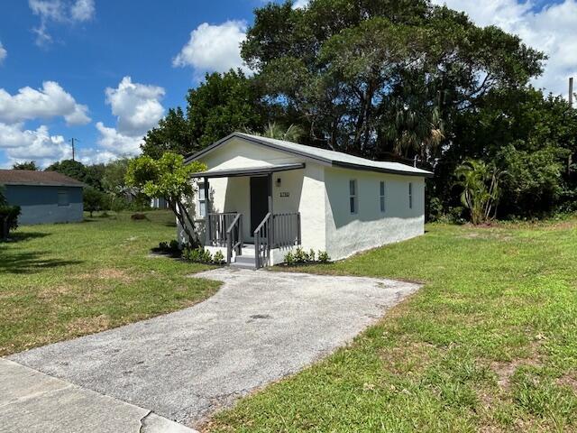 bungalow-style home with a front lawn