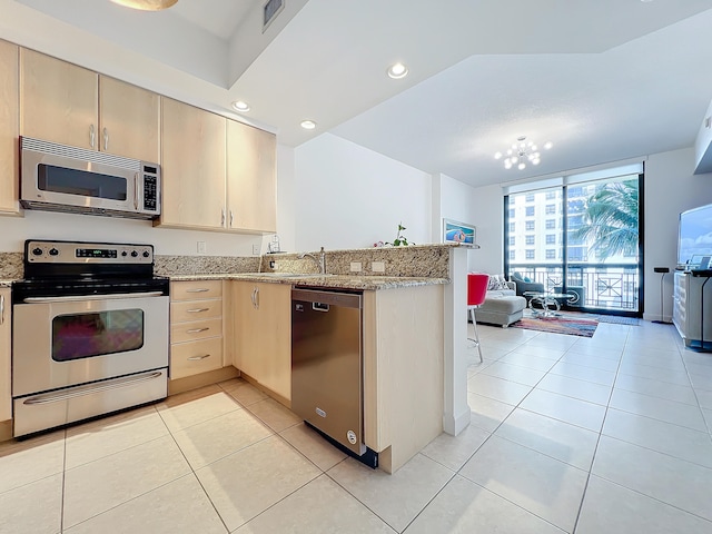 kitchen featuring light tile patterned flooring, kitchen peninsula, and stainless steel appliances