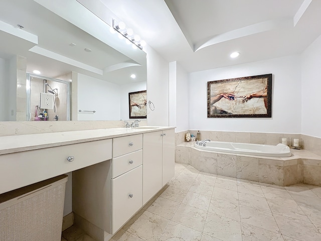 bathroom featuring vanity, independent shower and bath, and a raised ceiling