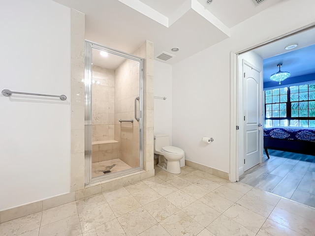 bathroom with a notable chandelier, a shower with shower door, and toilet